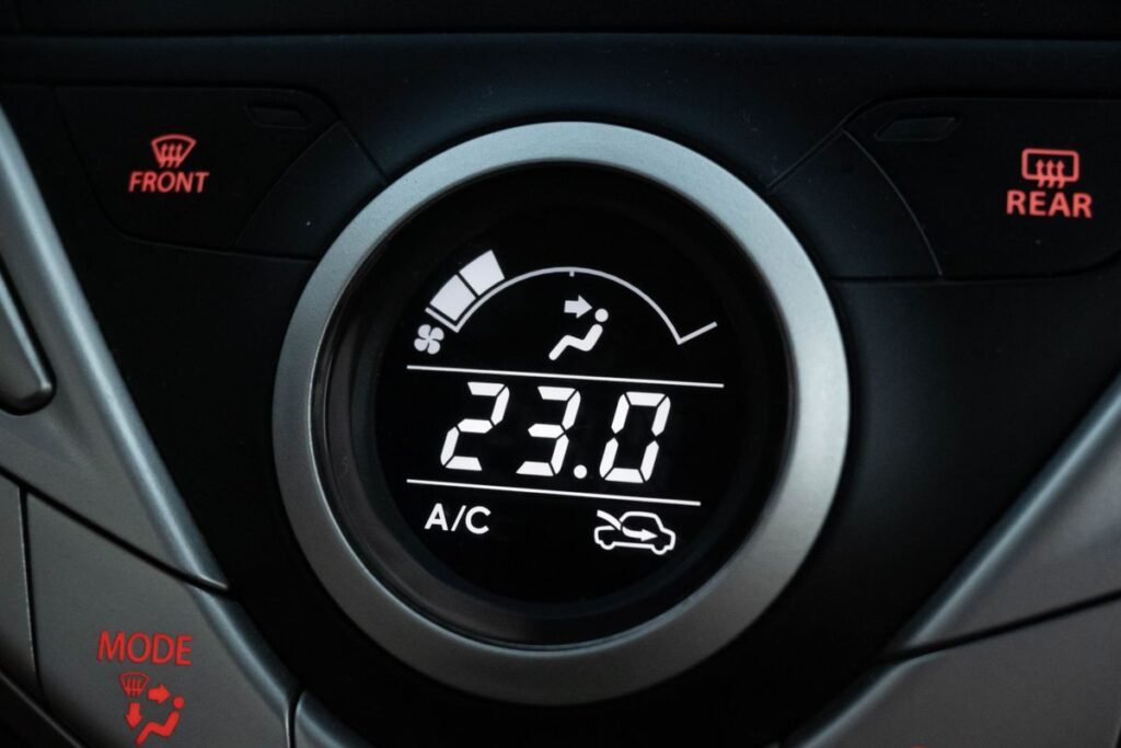 Close up of a car dashboard climate control display showing the AC setting