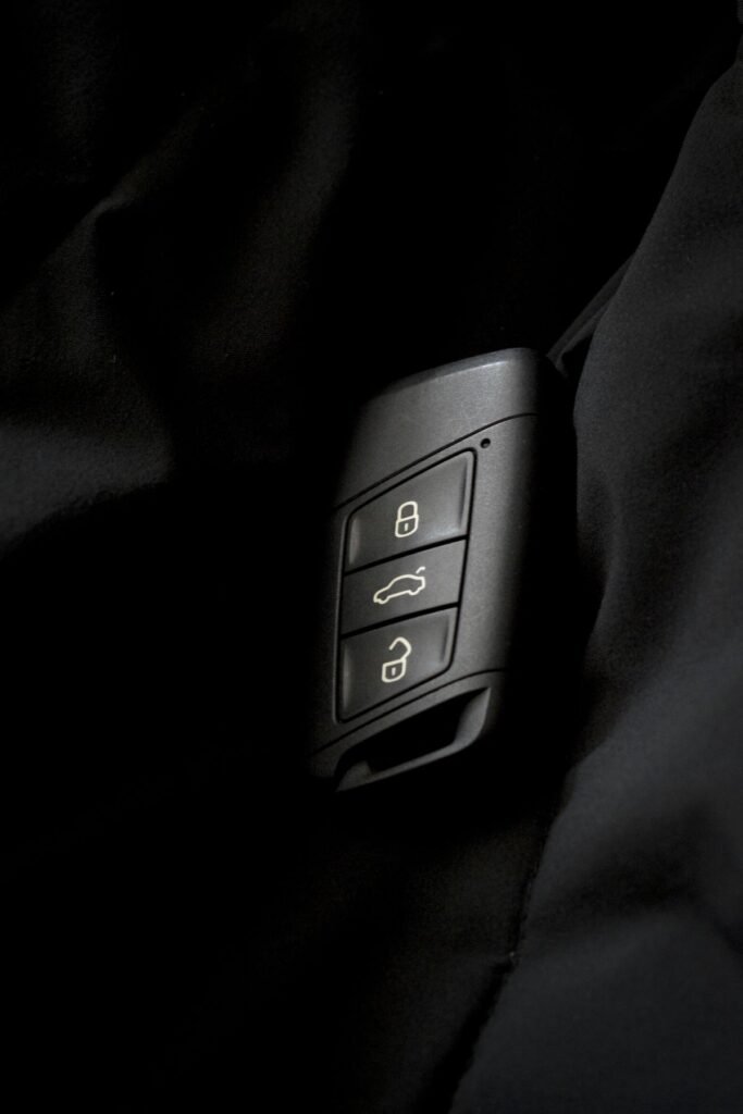 Detailed photo of a car key fob showing lock and unlock buttons on a dark surface