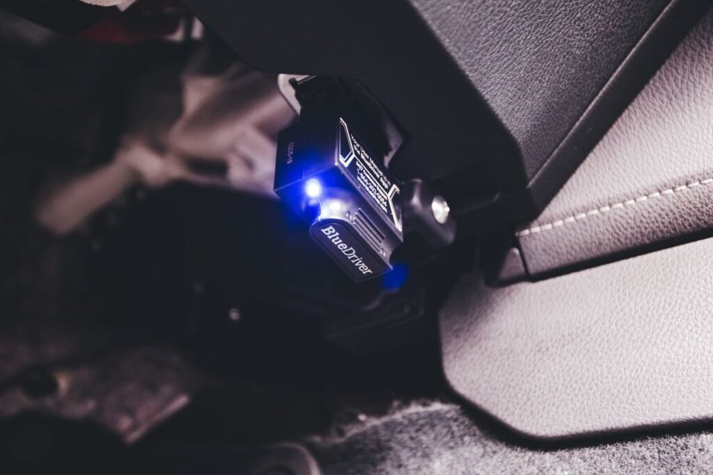 Bluetooth code reader plugged into a car with a blue glow