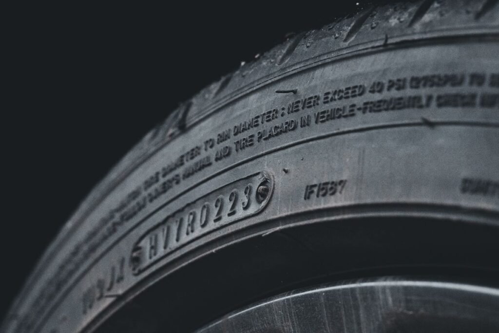 Close up of a car tire showing the sidewall text and tread