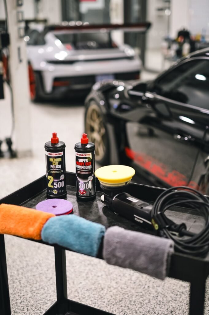 Car detailing sprays, cloths and products laid out on a table in a garage