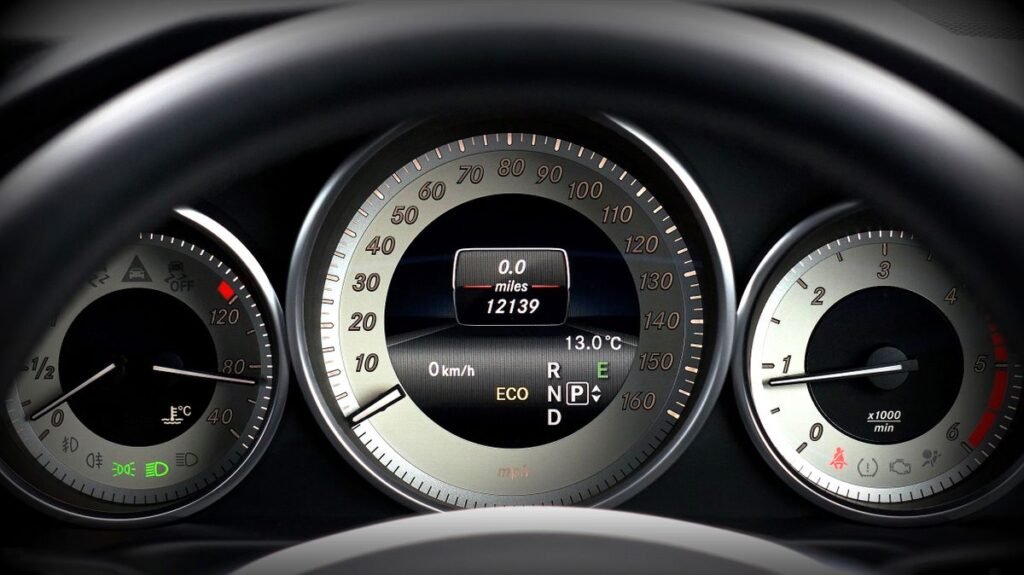 Close up of a car instrument cluster with speedometer, odometer and temperature gauge