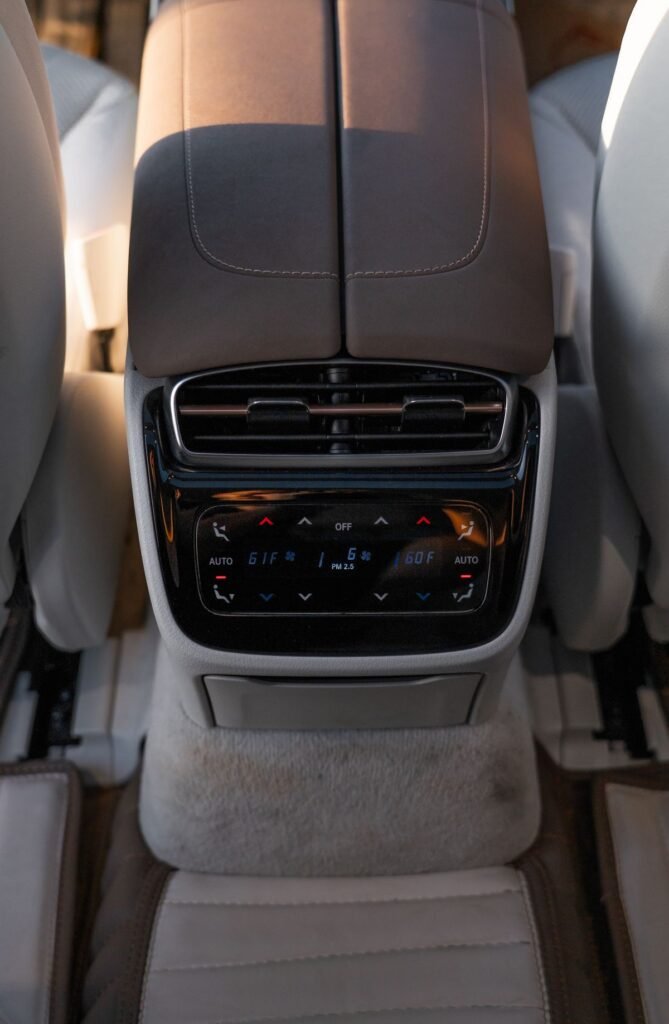 Close up of a luxury car rear console showing advanced climate control settings
