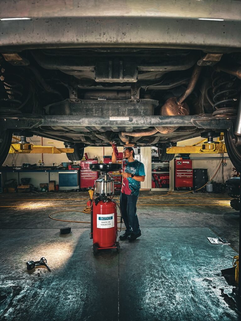 Mechanic inspecting the underside of a car on a lift in a repair shop