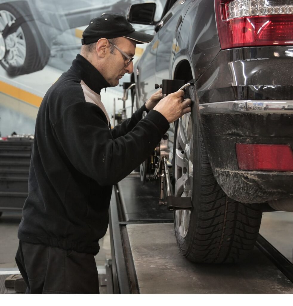Professional mechanic adjusting wheel alignment in an auto repair shop