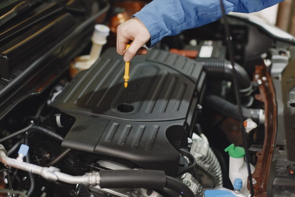 Close up of a person checking engine fluid with a dipstick in the engine bay