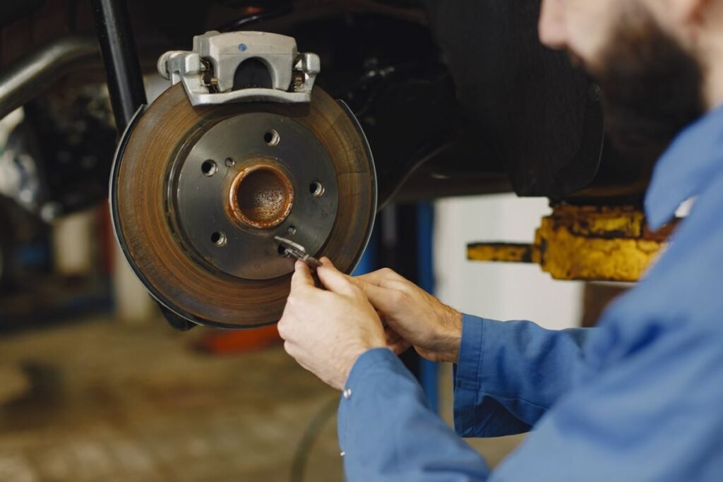 Mechanic hands working on a brake disc in a workshop, close up