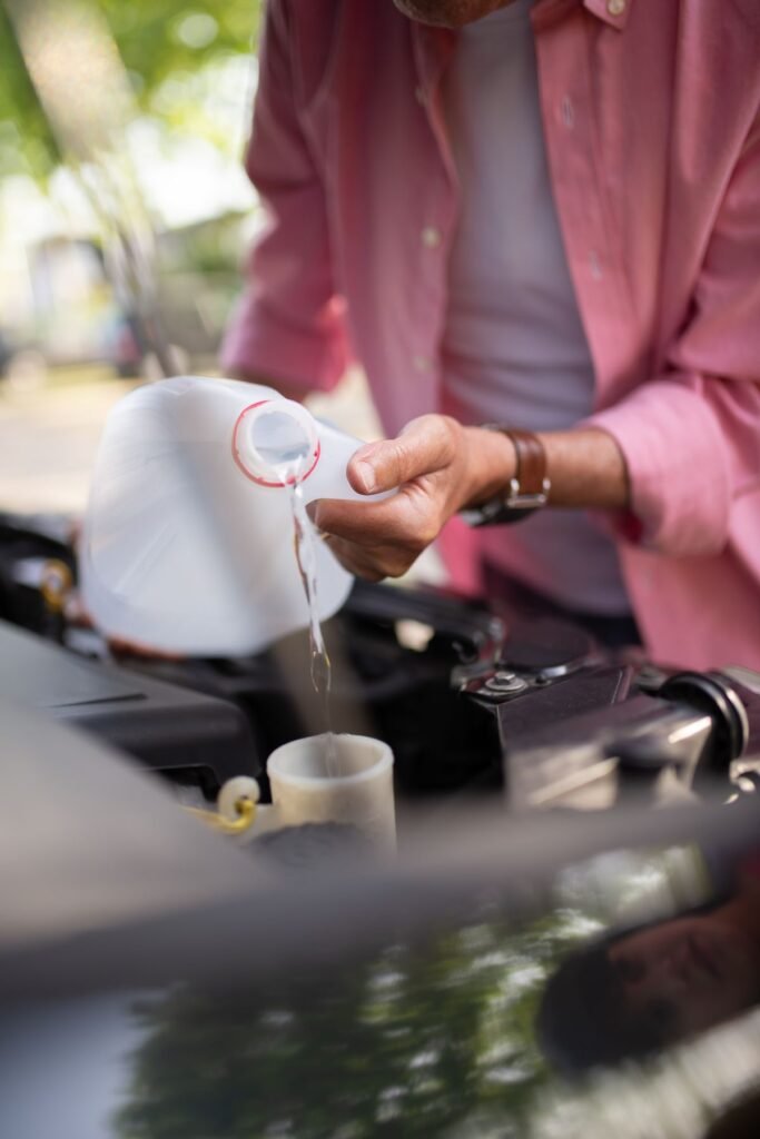 Man pouring coolant into a car engine