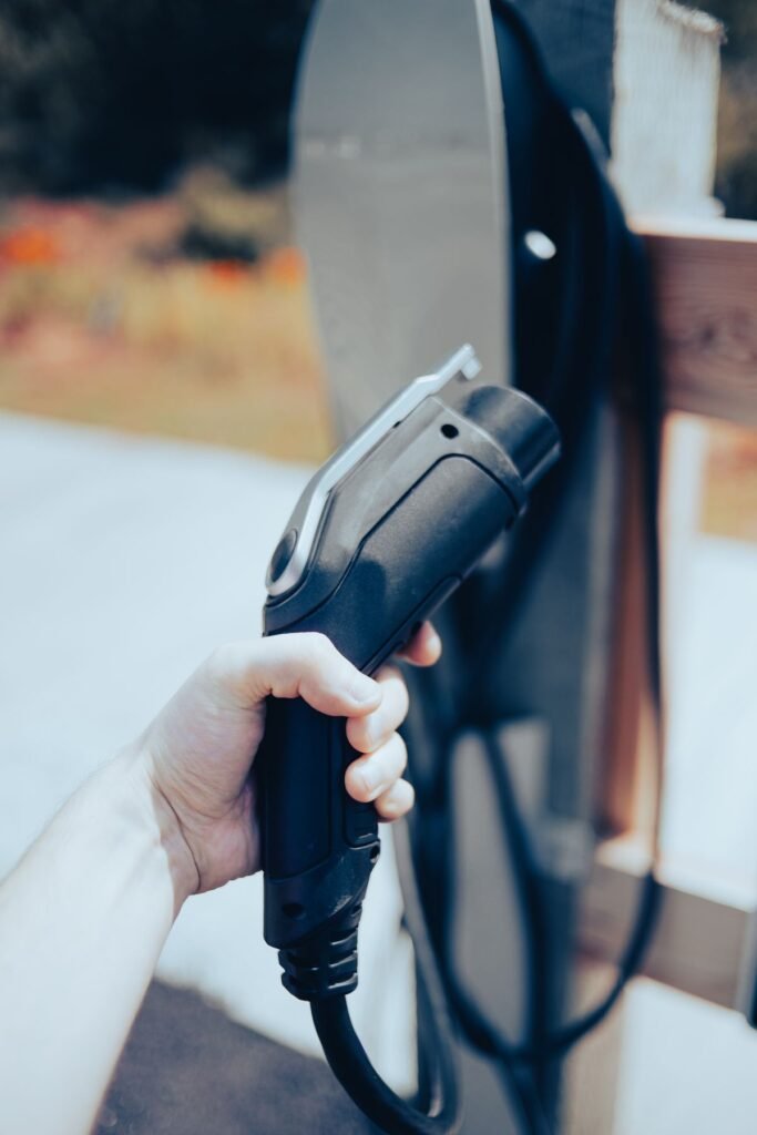 Close up of a hand holding an EV charging cable outdoors