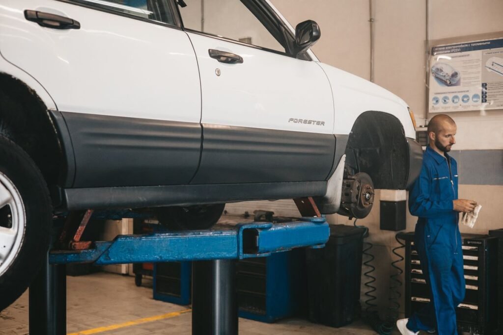Mechanic checking a car raised on a lift in a workshop